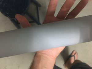 Inspecting paint job - 3 layers of primer on PVC tube.